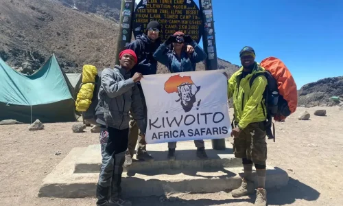 guide du Kilimandjaro prenant une photo avec des grimpeurs au camp